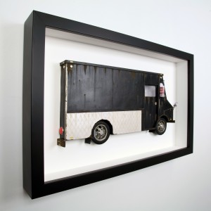 Drew Leshko -  <strong>Black and Silver LLV (side)</strong> (2016<strong style = 'color:#635a27'></strong>)<bR /> paper, enamel, dry pigments, acrylic, plastic, clay, wire, inkjet print, toy hubcaps. Framed in shadowbox without glass,
16 x 25.62 x 3 inches,
(40.64 x 65.07 x 7.62 cm)
