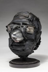 Ronald Gonzalez -  <strong>Cone (side)</strong> (2018<strong style = 'color:#635a27'></strong>)<bR /> black leather, found objects, wire, wax, carbon, screws and metal filings over welded steel armatures.  	11 x 9 x 10 inches
