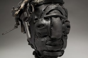 Ronald Gonzalez -  <strong>Dead Air (detail)</strong> (2018<strong style = 'color:#635a27'></strong>)<bR /> black leather, found objects, wire, wax, carbon, screws and metal filings over welded steel armatures,
18 x 10 x 8 inches