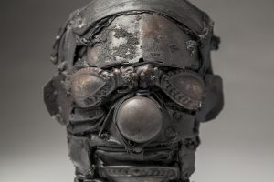 Ronald Gonzalez -  <strong>Mask (detail)</strong> (2018<strong style = 'color:#635a27'></strong>)<bR /> black leather, found objects, wire, wax, carbon, screws and metal filings over welded steel armatures,
10 x 8 x 8 inches
