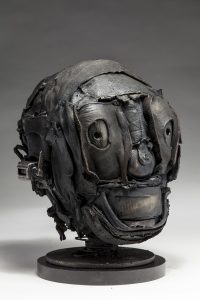 Ronald Gonzalez -  <strong>Skull (side)</strong> (2018<strong style = 'color:#635a27'></strong>)<bR /> black leather, found objects, wire, wax, carbon, screws and metal filings over welded steel armatures, 
11 x 7 x 9 inches