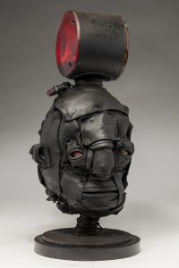 Ronald Gonzalez -  <strong>Signal (side)</strong> (2018<strong style = 'color:#635a27'></strong>)<bR /> black leather, found objects, wire, wax, carbon, screws and metal filings over welded steel armatures,
16 x 7 x 8 inches