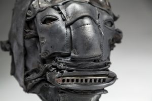 Ronald Gonzalez` -  <strong>Tune (detail)</strong> (2018<strong style = 'color:#635a27'></strong>)<bR /> black leather, found objects, wire, wax, carbon, screws and metal filings over welded steel armatures,
12 x 8 x 10 inches