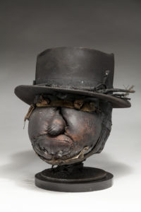 Ronald Gonzalez -  <strong>MUG</strong> (2018<strong style = 'color:#635a27'></strong>)<bR /> 11 x 10 x 12. Leather, found objects, wire, wax, carbon, screws, and metal filings over welded steel armatures.