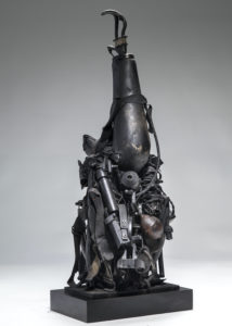 Ronald Gonzalez -  <strong>PROSTHETIC</strong> (2018<strong style = 'color:#635a27'></strong>)<bR /> 30 x 12 x 8. Leather, found objects, wire, wax, carbon, screws, and metal filings over welded steel armatures.