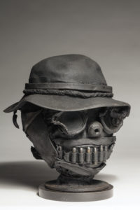 Ronald Gonzalez -  <strong>SMILE</strong> (2017<strong style = 'color:#635a27'></strong>)<bR /> 13 x 11 x 12. Leather, found objects, wire, wax, carbon, screws, and metal filings over welded steel armatures.